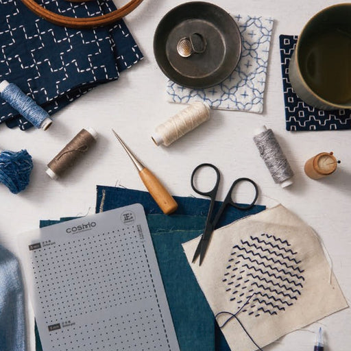 Sashiko template set with fabric, thread, and tools on a white background