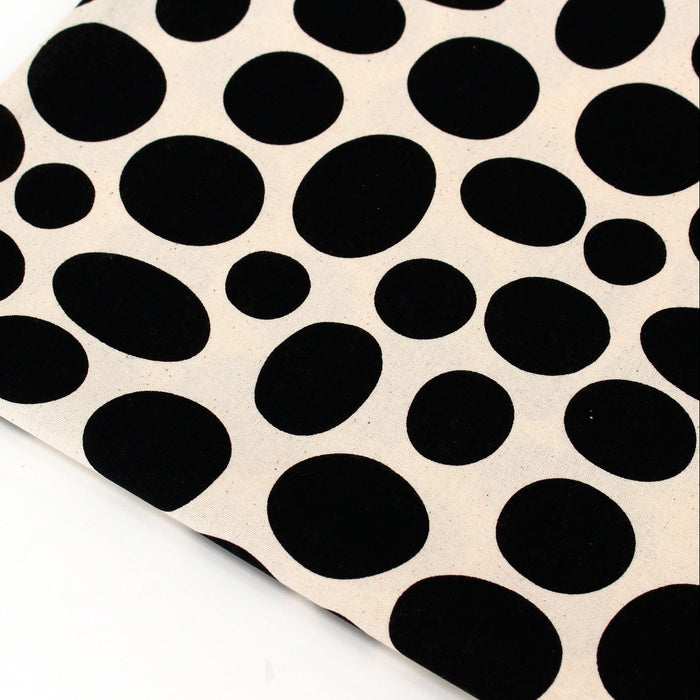 Sheet of black oval stickers on a beige background