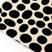 Sheet of black oval stickers on a beige background