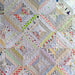 Quilt with a geometric pattern featuring various colors and textures.