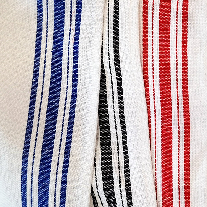 Close-up of fabric with blue, black, and red stripes on a white background