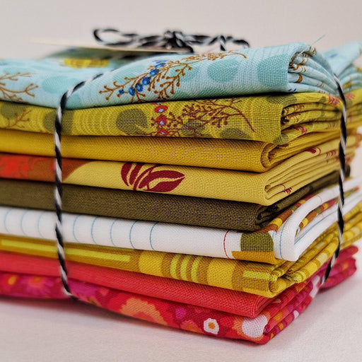 Stack of colorful fabric bundles tied together on a light background