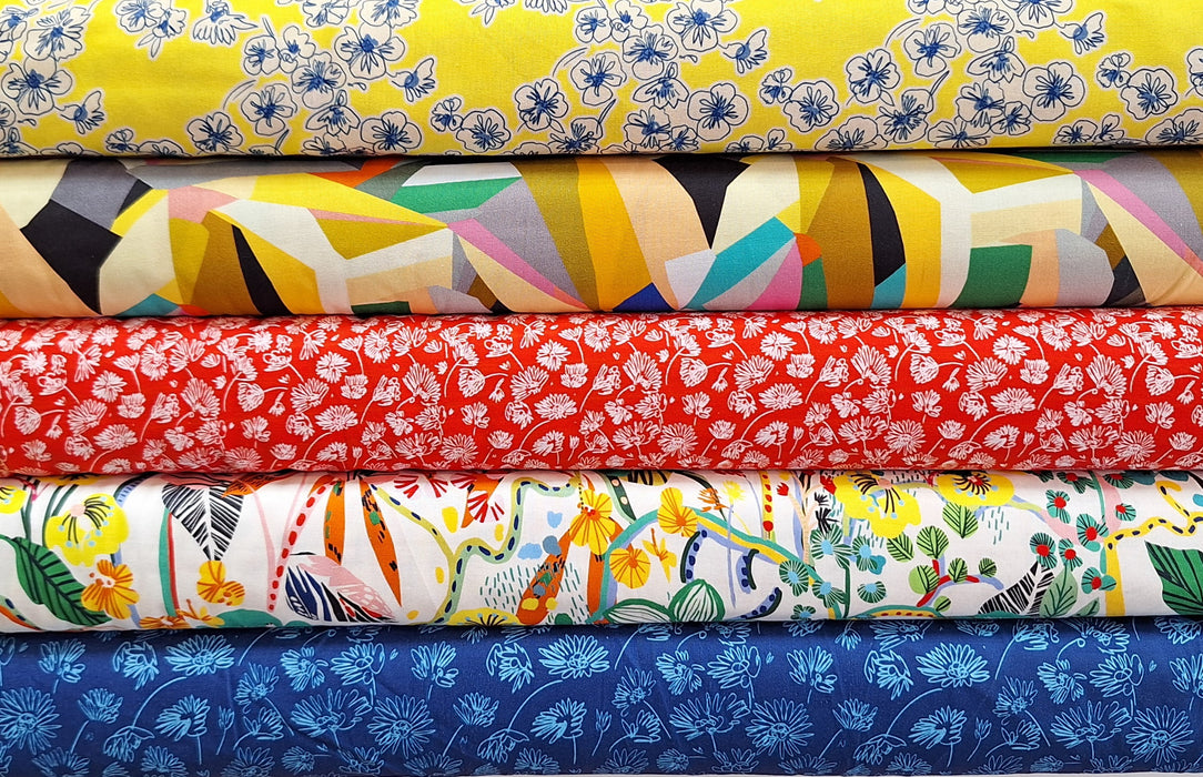 Stack of colorful fabric swatches with various patterns