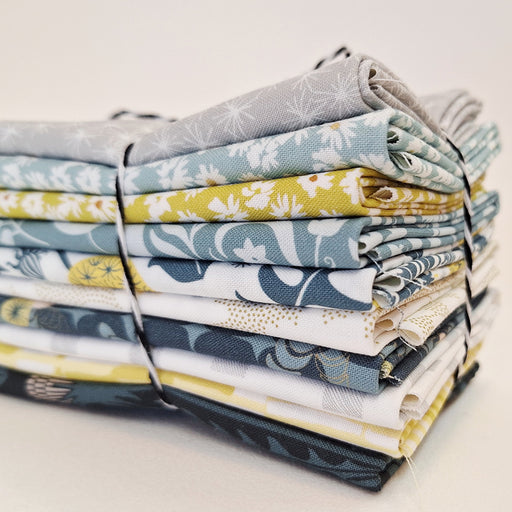 Stack of colorful fabric bundles tied together on a light background