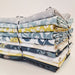 Stack of colorful fabric bundles tied together on a light background
