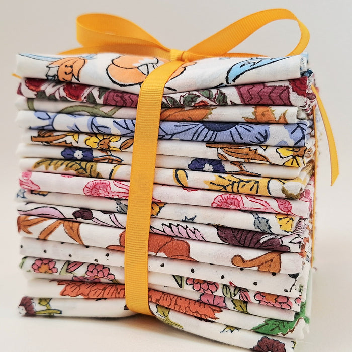 Stack of colorful fabric rolls tied with a yellow ribbon on a light background