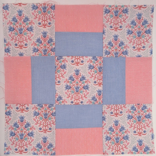 quilt block made up of pink and blue fabrics
