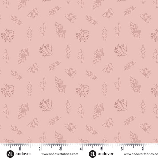 Pink fabric with small leaf patterns and a ruler at the bottom for scale.