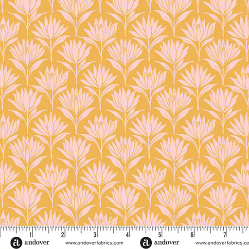 A repeating floral pattern fabric swatch with pale pink stylized flower motifs on a warm mustard yellow background, shown with a ruler along the bottom edge for scale. Andover branding is visible at the bottom.