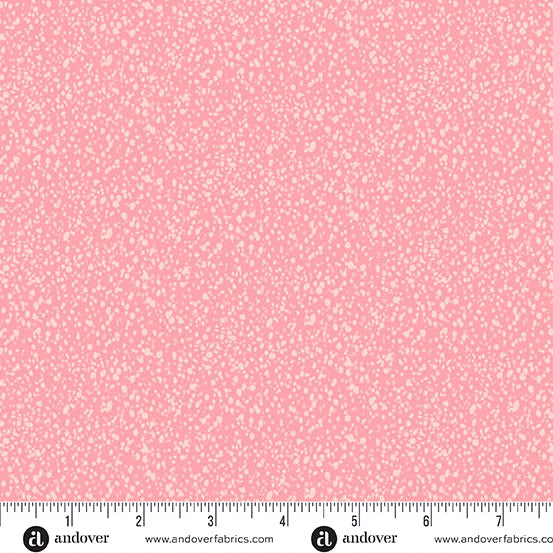 Pink fabric with a small white pattern and a ruler at the bottom for scale.