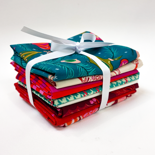 A stack of folded patterned fabric pieces tied with a white ribbon, photographed on a clean white background.