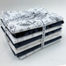 Stack of folded fabric with animal prints tied with a ribbon on a white background