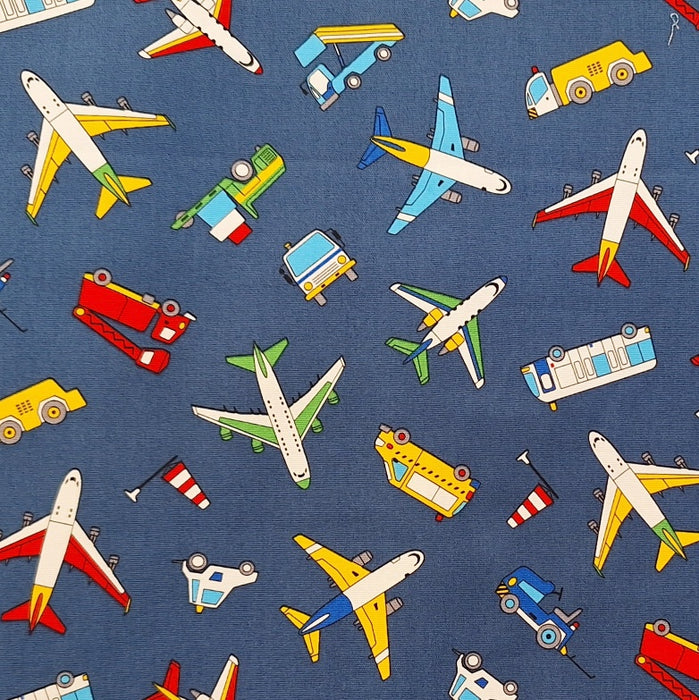 close up of fabric with trucks, planes, busses and construction vehicles
