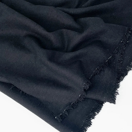 Black fabric with frayed edges on a white background