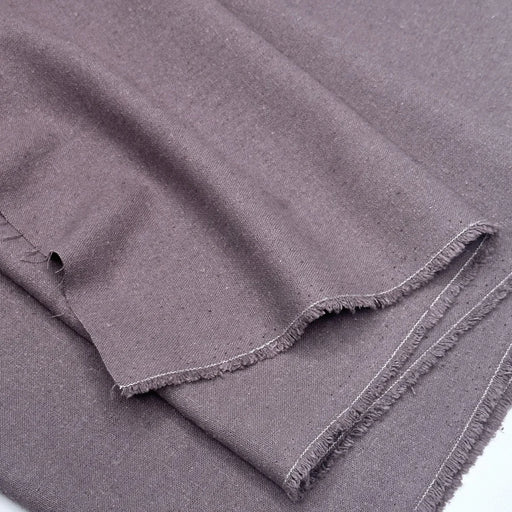 Folded grape fabric with frayed edges on a white background