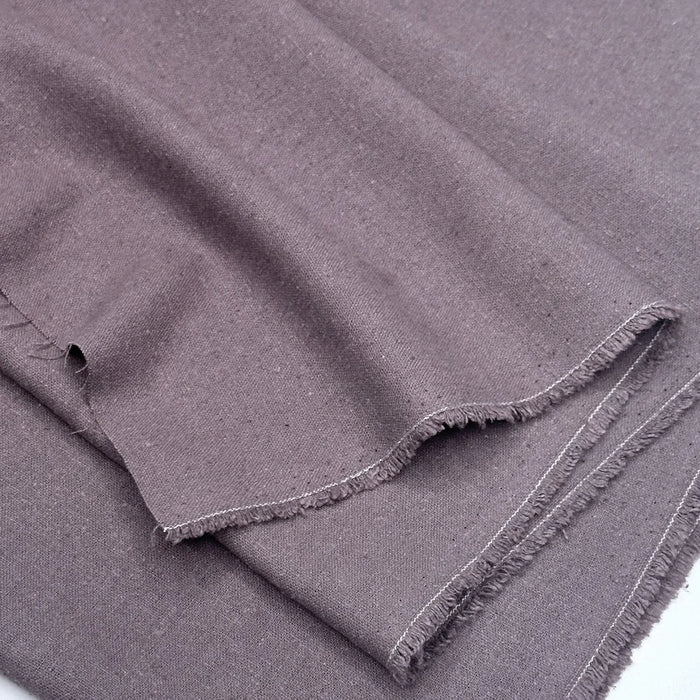 Folded grape fabric with frayed edges on a white background