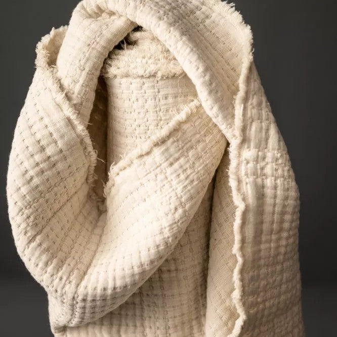 Close-up of a textured beige fabric with a dark background