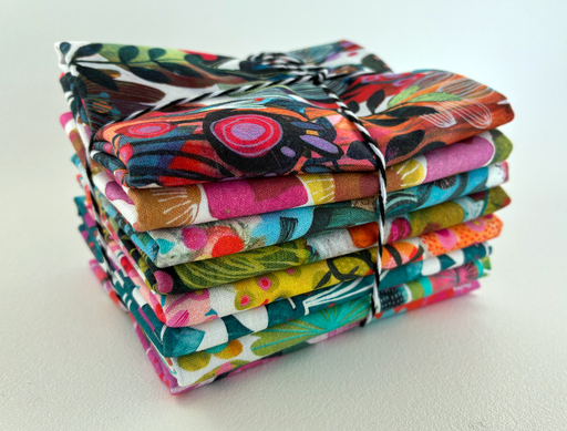 Stack of colorful fabric bundles on a white background