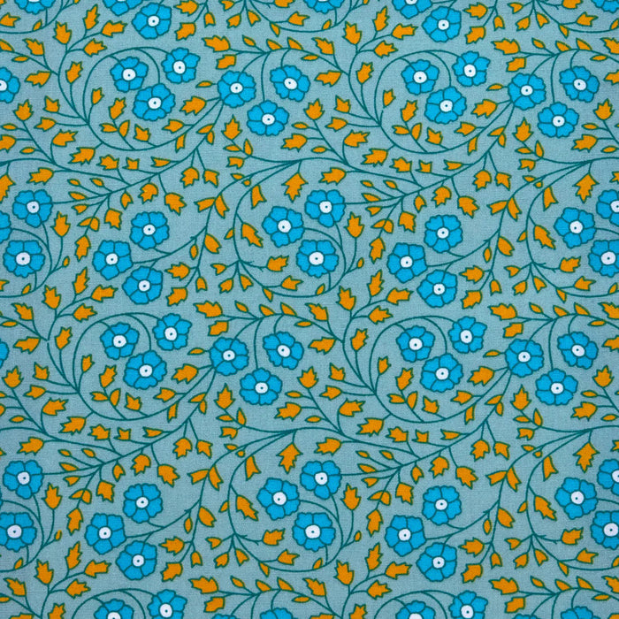 Patterned fabric with blue flowers and orange leaves on a blue background