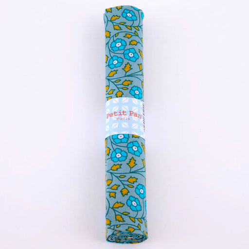 Rolled-up fabric with floral pattern and 'Petit Pas' branding on a white background