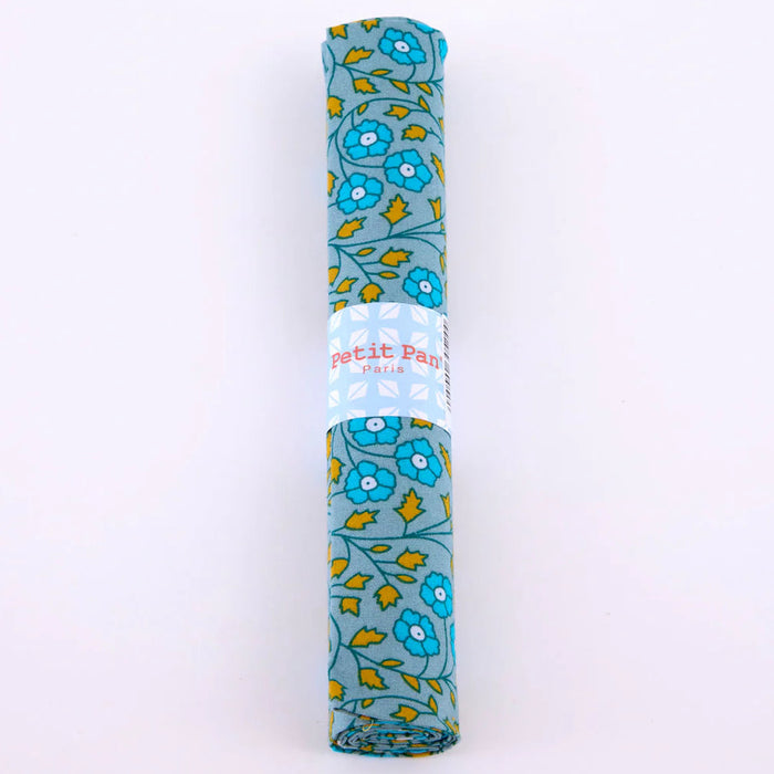Rolled-up fabric with floral pattern and 'Petit Pas' branding on a white background