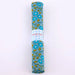 Rolled-up fabric with floral pattern and 'Petit Pas' branding on a white background