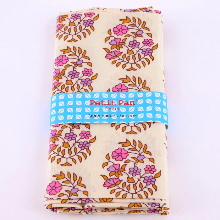 Folded fabric with floral pattern and 'Petit Pan' label on a white background