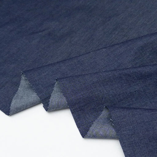 Stack of blue denim fabric on a white background