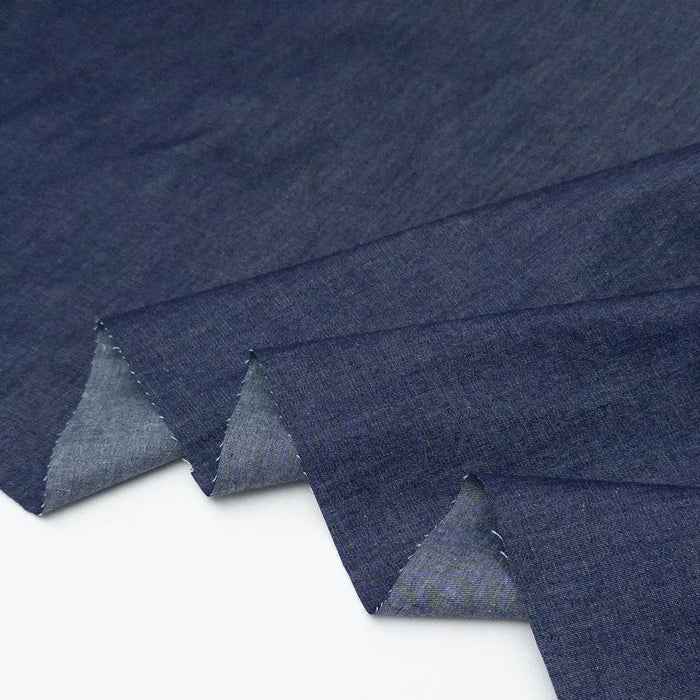 Stack of blue denim fabric on a white background