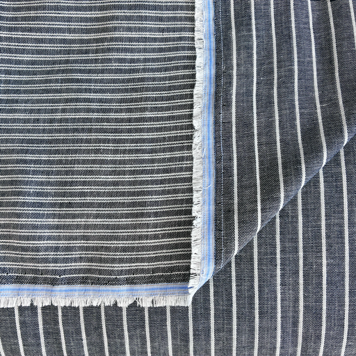 Close-up of blue and white striped fabric with frayed edges
