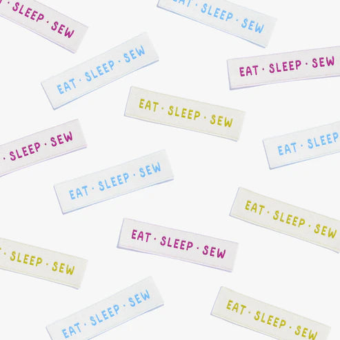 Multiple 'Eat Sleep Sew' labels in various colors on a white background