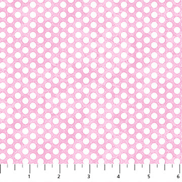 Pink fabric with white polka dots and a ruler at the bottom for scale.