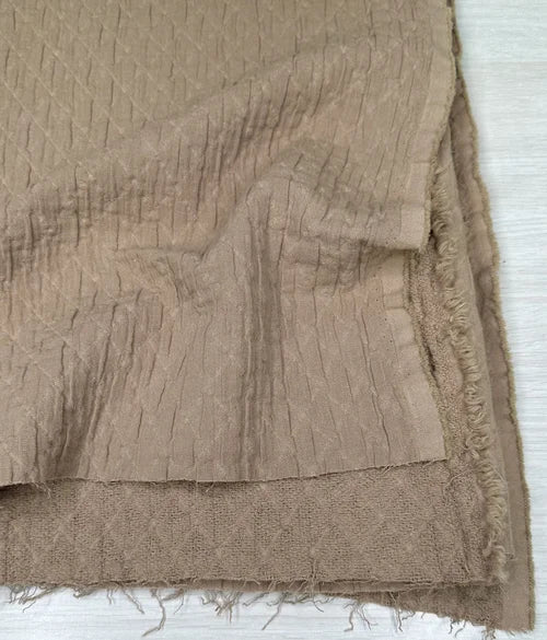 Brown textured fabric with frayed edges on a white background