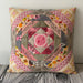 Patchwork pillow with colorful patterns on a wooden surface