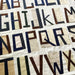 Quilt with fabric letters spelling out the alphabet on a white background