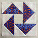 Quilt blocks with blue and orange floral patterns on a beige background