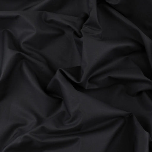 Polished black cotton crinkled in the centre to show drape