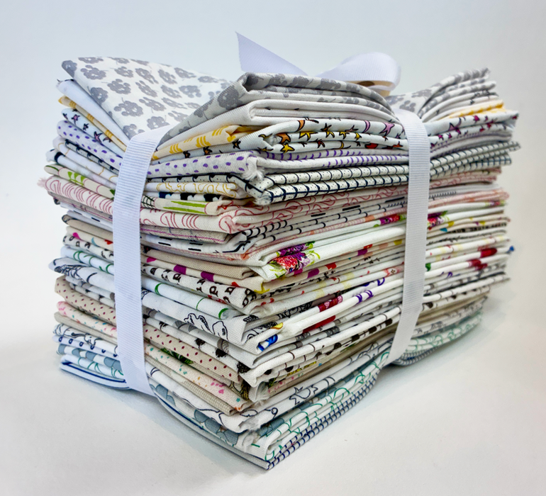 A bundle of folded patterned fabric pieces tied together with white ribbon bands, photographed on a clean white background.