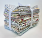 A bundle of folded patterned fabric pieces tied together with white ribbon bands, photographed on a clean white background.