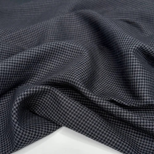 Close-up of dark gray fabric with a subtle pattern on a white background