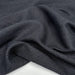 Close-up of dark gray fabric with a subtle pattern on a white background