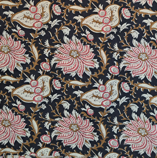 A close-up of a black patterned fabric featuring large pink and white floral motifs with gold and brown vine details.
