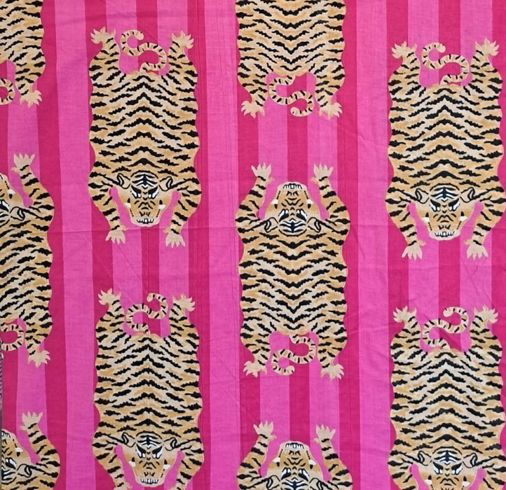 A close-up of a fabric pattern featuring pink and magenta vertical stripes with cartoonish tigers in tan, black, and pink.