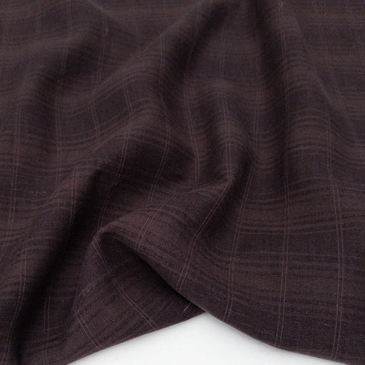 Close-up of brown fabric with a subtle check pattern on a white background