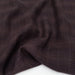 Close-up of brown fabric with a subtle check pattern on a white background