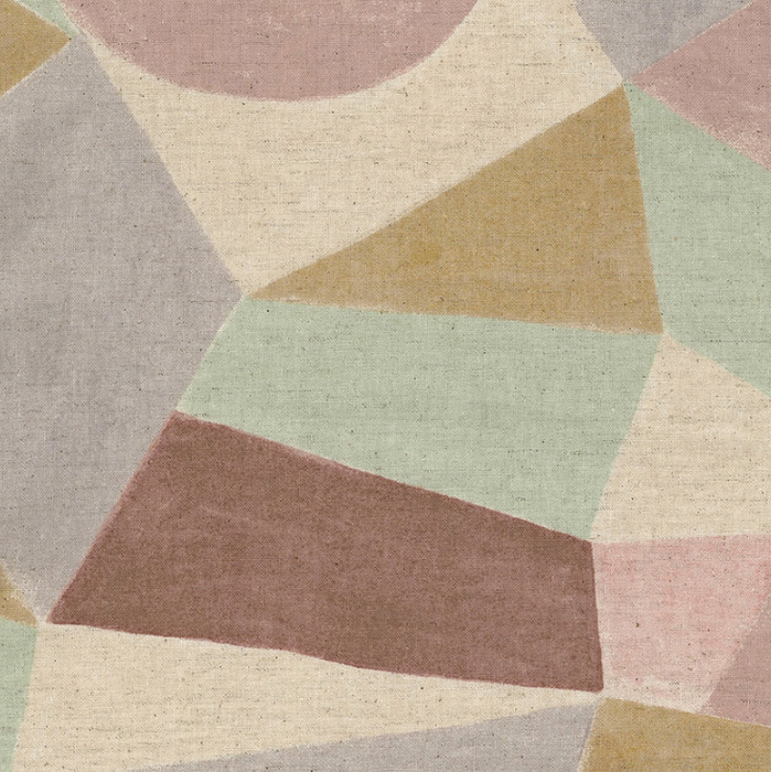 A close-up of a textured fabric pattern featuring a geometric design of irregular polygon shapes in muted pastel tones of sage green, dusty rose, mauve, ochre, and light gray on a cream base.