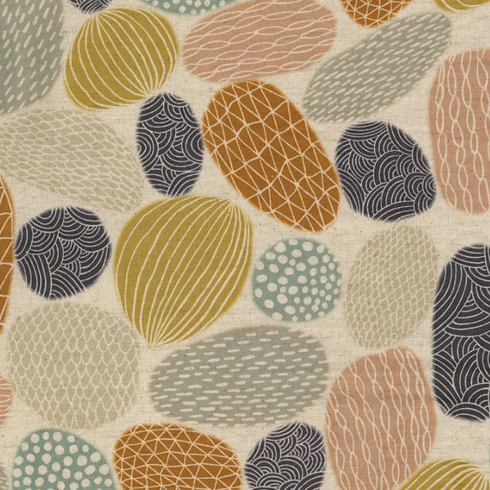A close-up of a fabric pattern featuring organic, abstract shapes in mustard yellow, terracotta orange, dusty pink, sage green, and charcoal gray on a warm cream background.