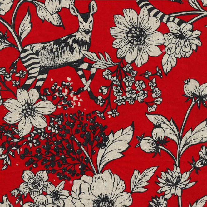 close up of fabric swatch with black and white animals and florals on a red background