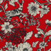 close up of fabric swatch with black and white animals and florals on a red background