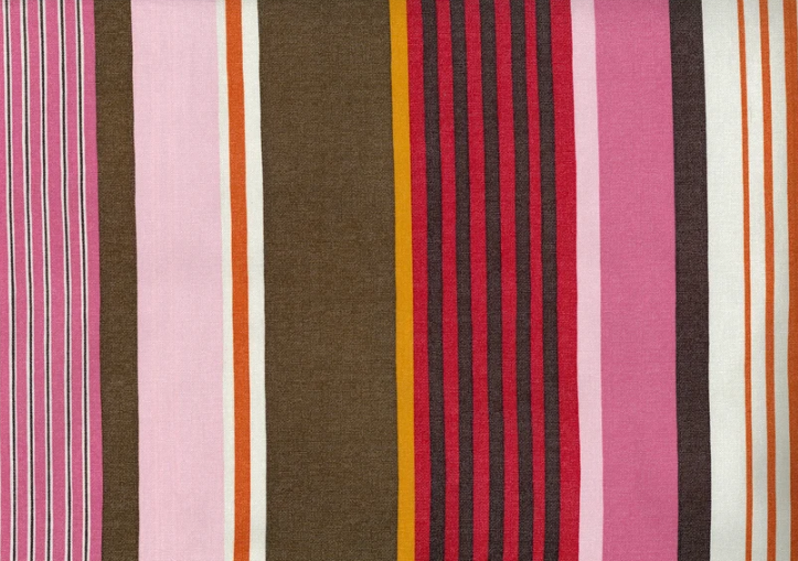 close up of striped fabric, with pinks, reds, and browns in varying width stripes.
